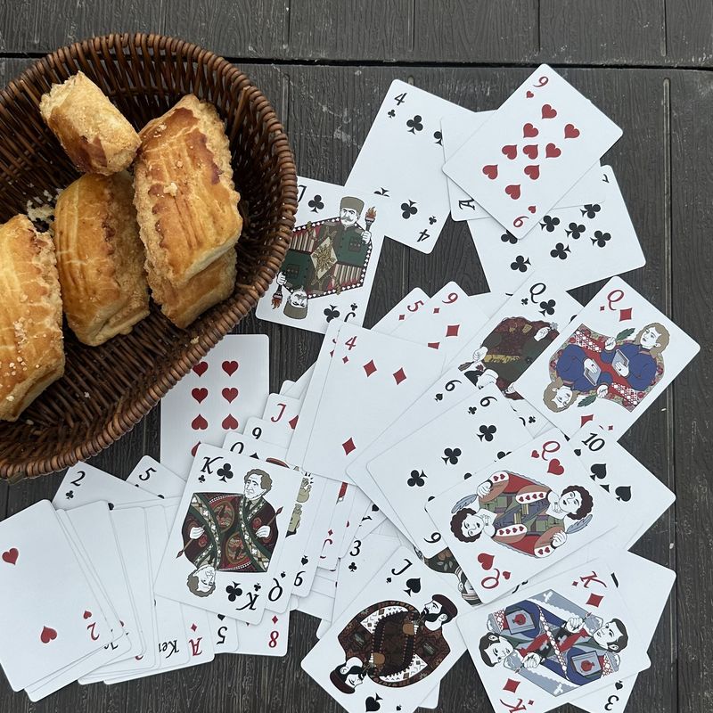 The Fragments deck dealt out across a dark wood table beside a basket of pastries